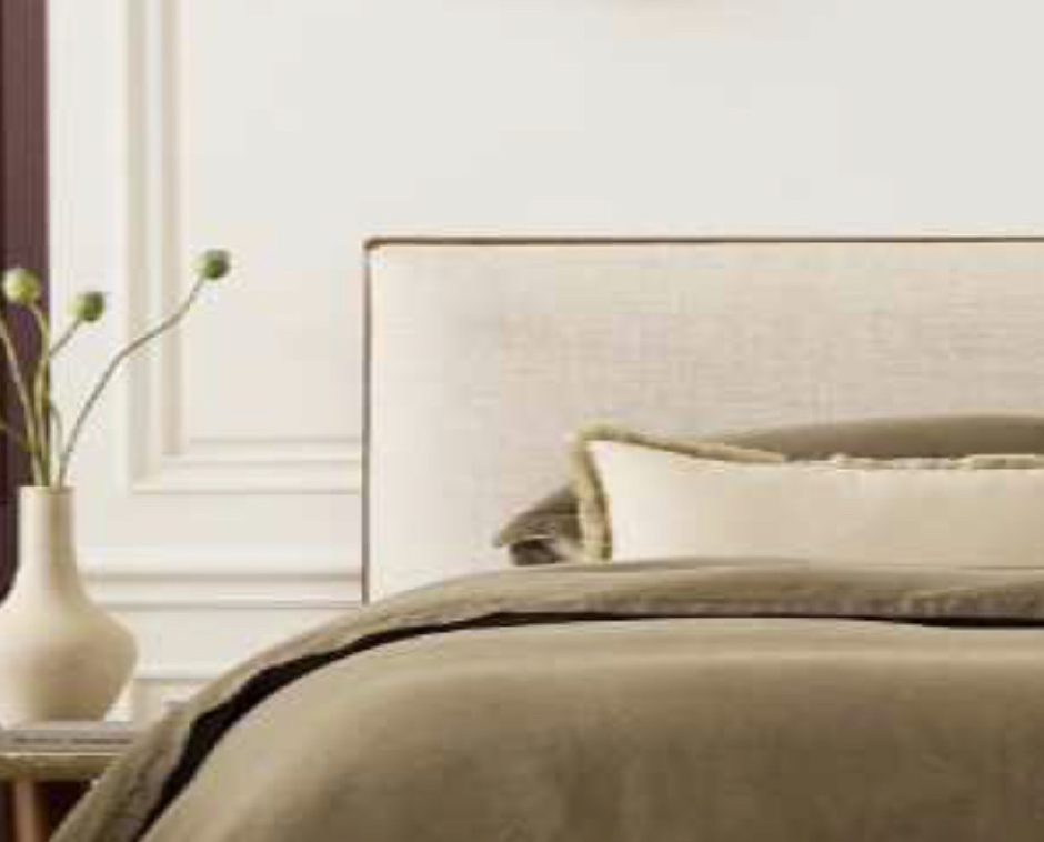 bed with beige sheets against a white interior